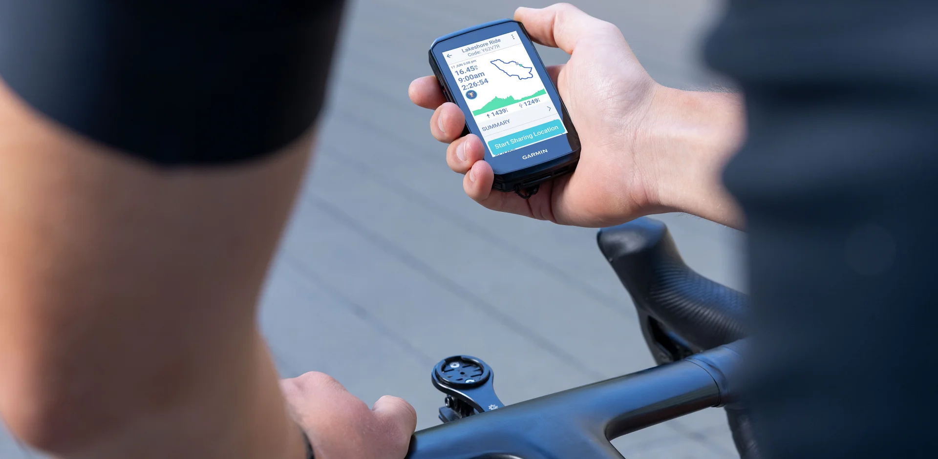 Licznik Garmin Edge 1060 trzymany w ręku kolarza z włączonym ekranem podsumowania jazdy