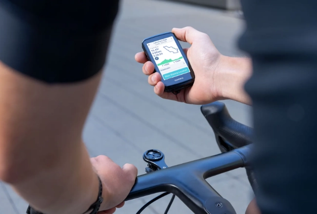 Garmin Edge 1060 trzymany w ręce przez kolarza